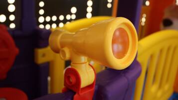 A close-up of a child's toy with a yellow and red structure, possibly a part of a ride or play equipment.