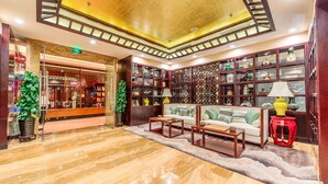A hotel lobby with a marble floor, a sofa set, a red lamp, and a decorative wall with shelves. - Hotel Nikko Dalian (Dalian)