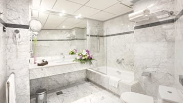Een bad/douchecombinatie, designer toiletartikelen, een haardroger