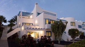 Un edificio moderno con un diseño arquitectónico único, que destaca por una escalera prominente y un balcón.