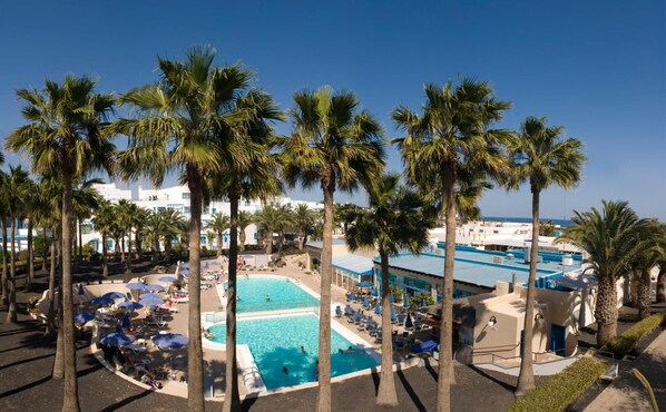 Een buitenzwembad, parasols voor strand/zwembad