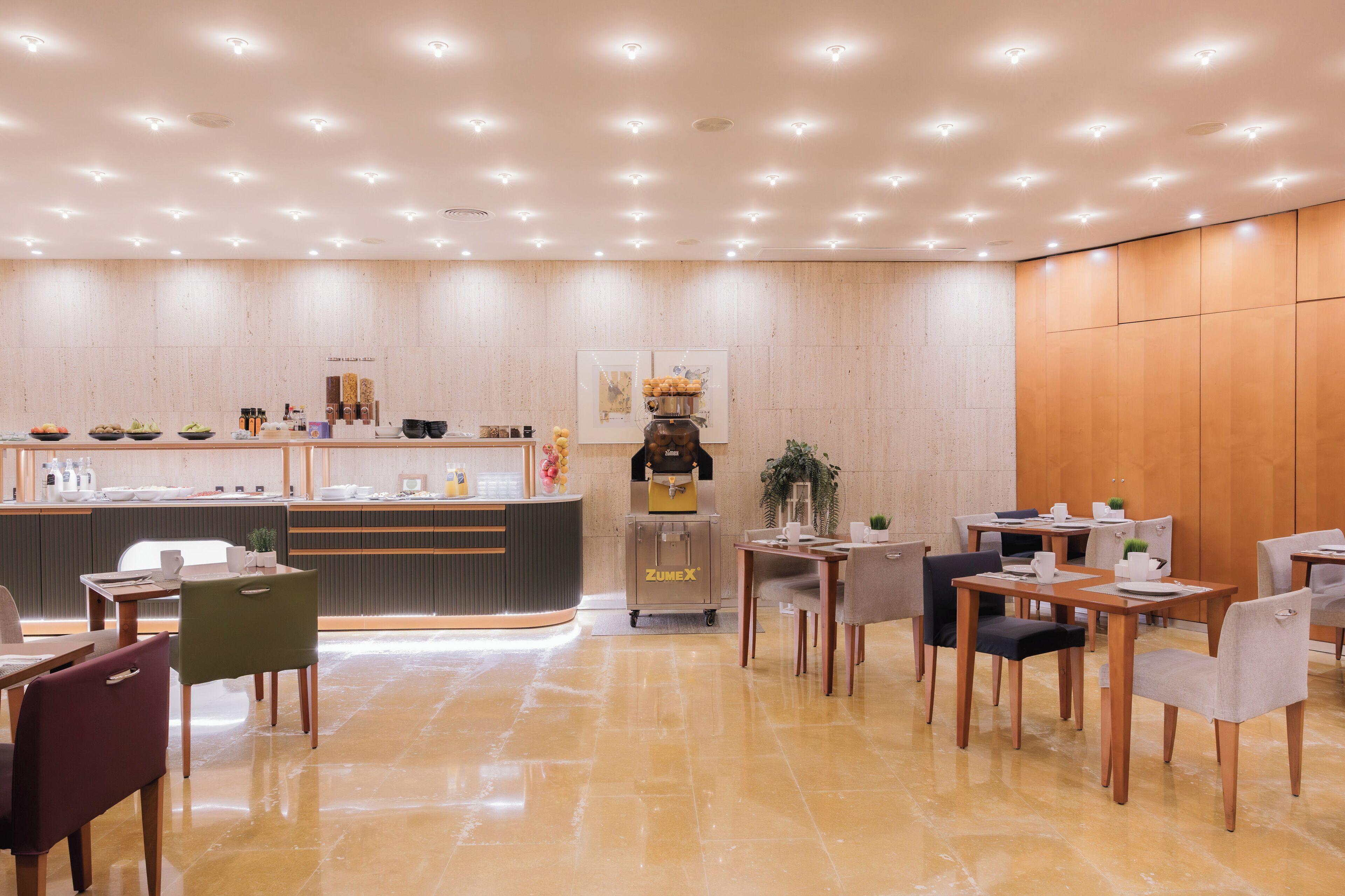 A modern hotel lobby with a reception desk, seating area, and a clean, polished floor.