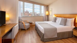 A hotel room with a large bed, a desk with a TV, and a chair. - Hotel Castellon Center Affiliated by Meliá (Castelló de la Plana)