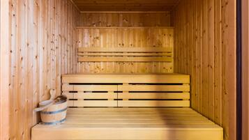 Una sauna de madera con bancos y un cubo.