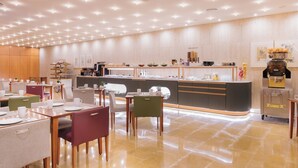 A modern restaurant with a central counter, multiple dining tables, and chairs. - Hotel Castellon Center Affiliated by Meliá (Castelló de la Plana)