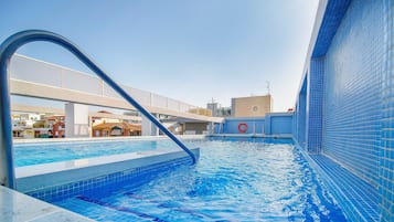 Una piscina al aire libre, tumbonas