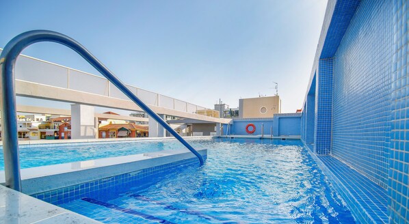 Una piscina al aire libre, tumbonas