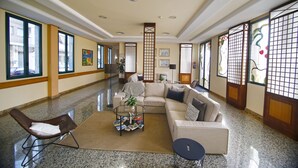 A spacious lobby with a modern sofa, a glass coffee table, and a comfortable chair. - Hotel Mainake (Velez-Malaga)