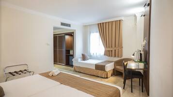 A hotel room with a bed, a desk, a chair, and a wardrobe.