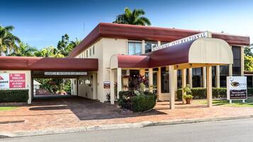 A hotel with a red roof, a covered entrance, and signs indicating free wireless broadband and a conference room.