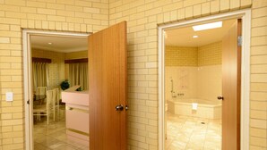 A bathroom with a bathtub and a shower. - Bundaberg International Motor Inn (Millbank)