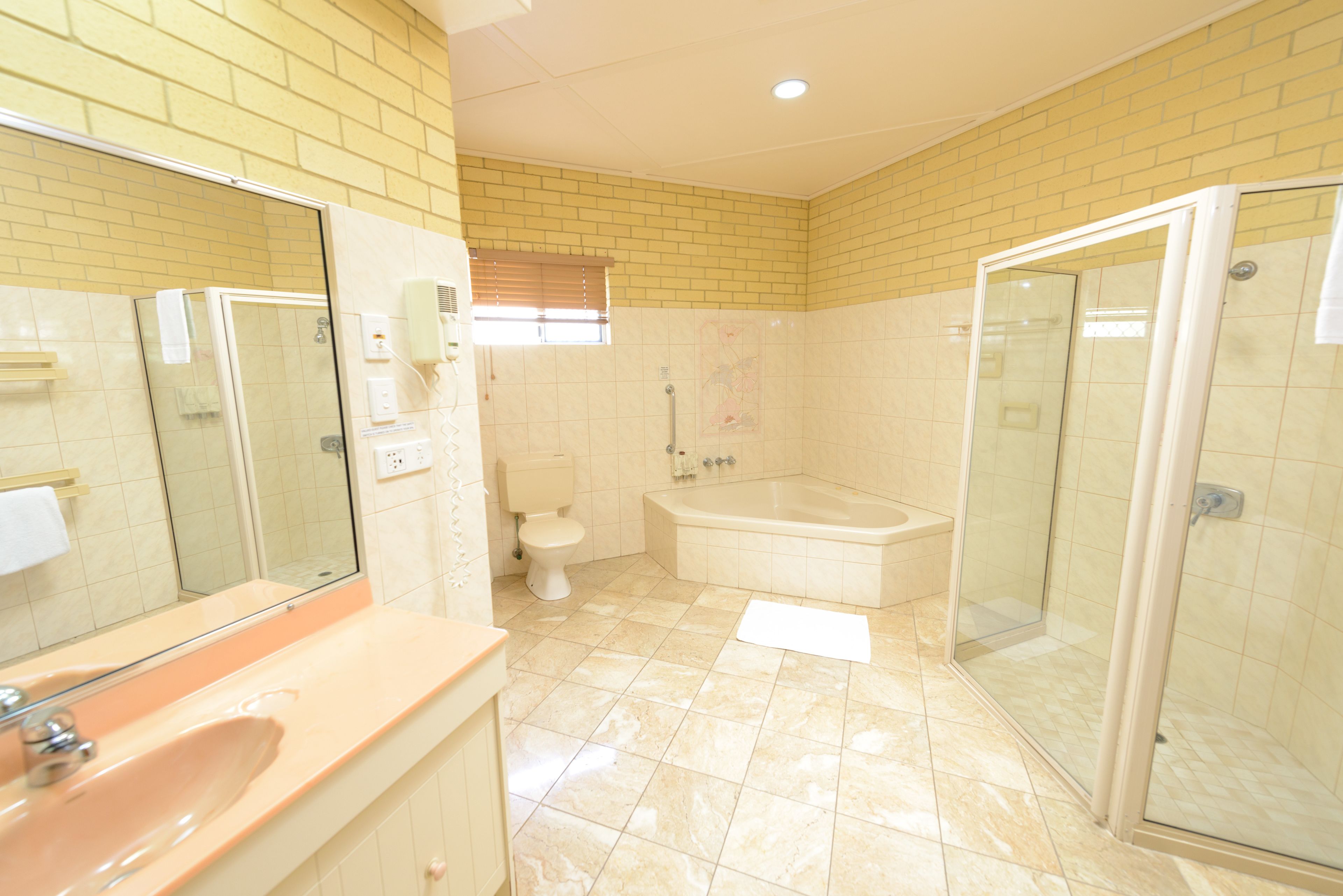 A bathroom with a sink, mirror, toilet, bathtub, and glass shower enclosure.