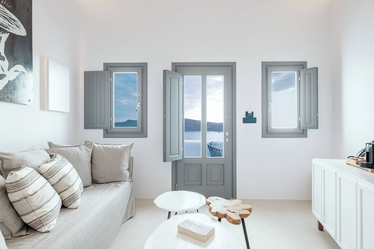 A modern living room with a sofa, a coffee table, and a view through a door.