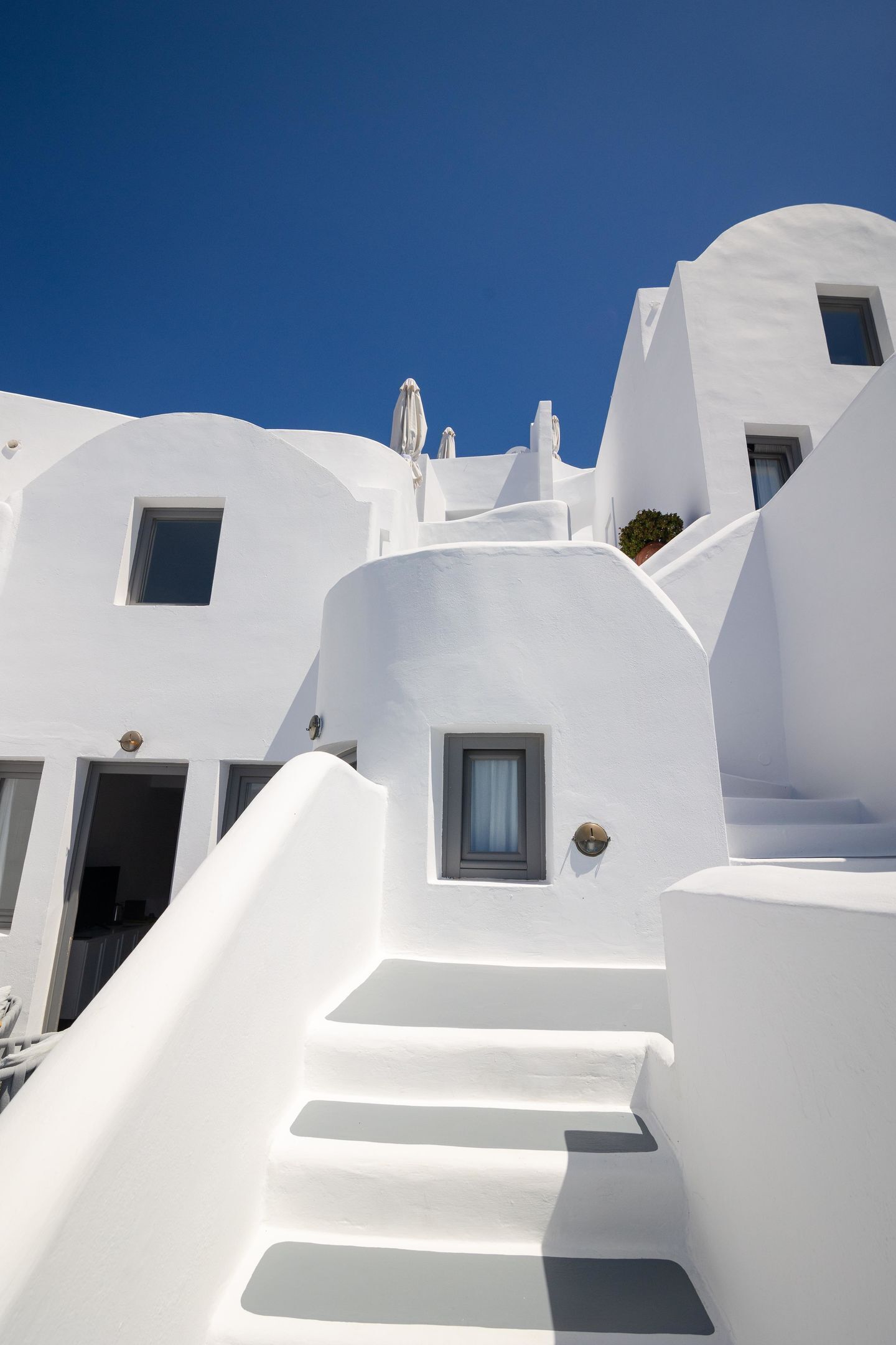 A white building with a staircase leading up to a door.
