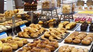Una vitrina de pastelería con diversos pasteles y productos horneados.