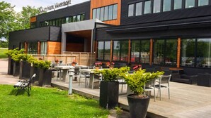 A modern hotel with outdoor seating and large windows. - Quality Hotel Vanersborg (Vanersborg)