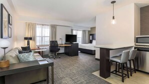 A hotel room with a bed, a desk, a TV, a sofa, and a dining area. - Residence Inn by Marriott Denver Golden/Red Rocks (Golden)