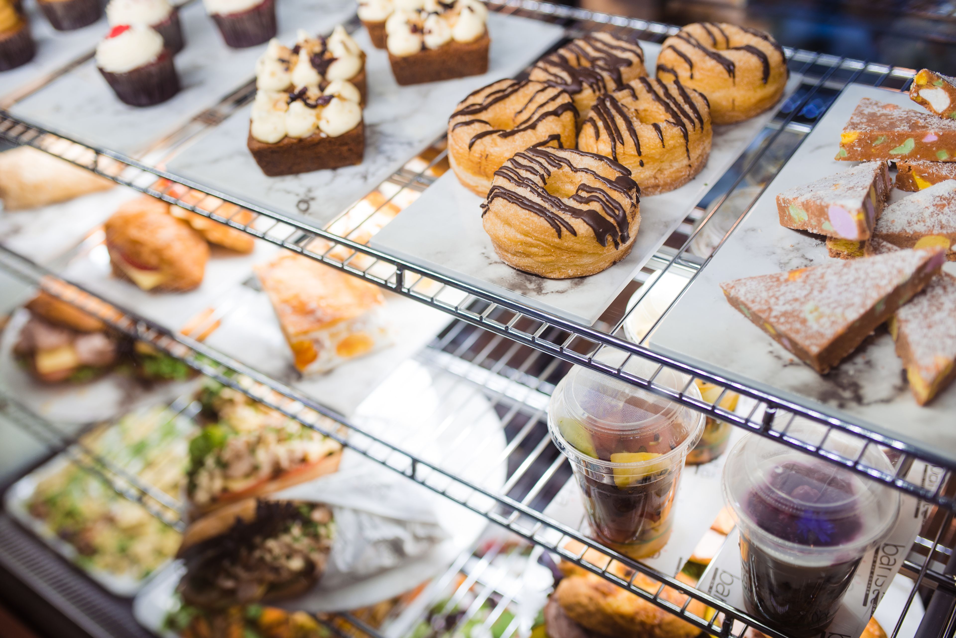 A bakery display with various baked goods and beverages.