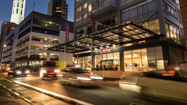 A modern hotel with a prominent tower and a glass facade. - Rydges Auckland (Auckland)