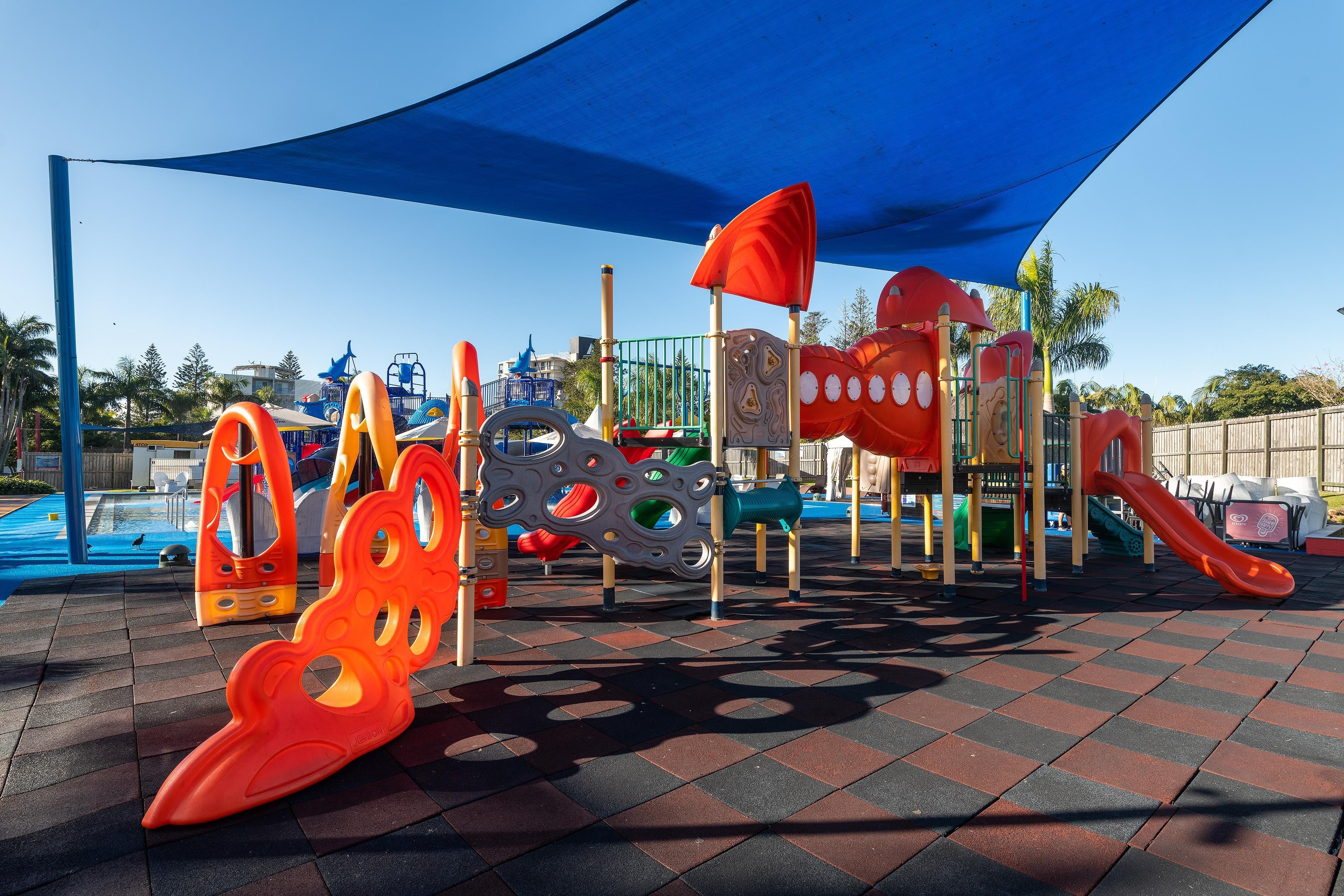 A playground with various play structures including slides and climbing areas.