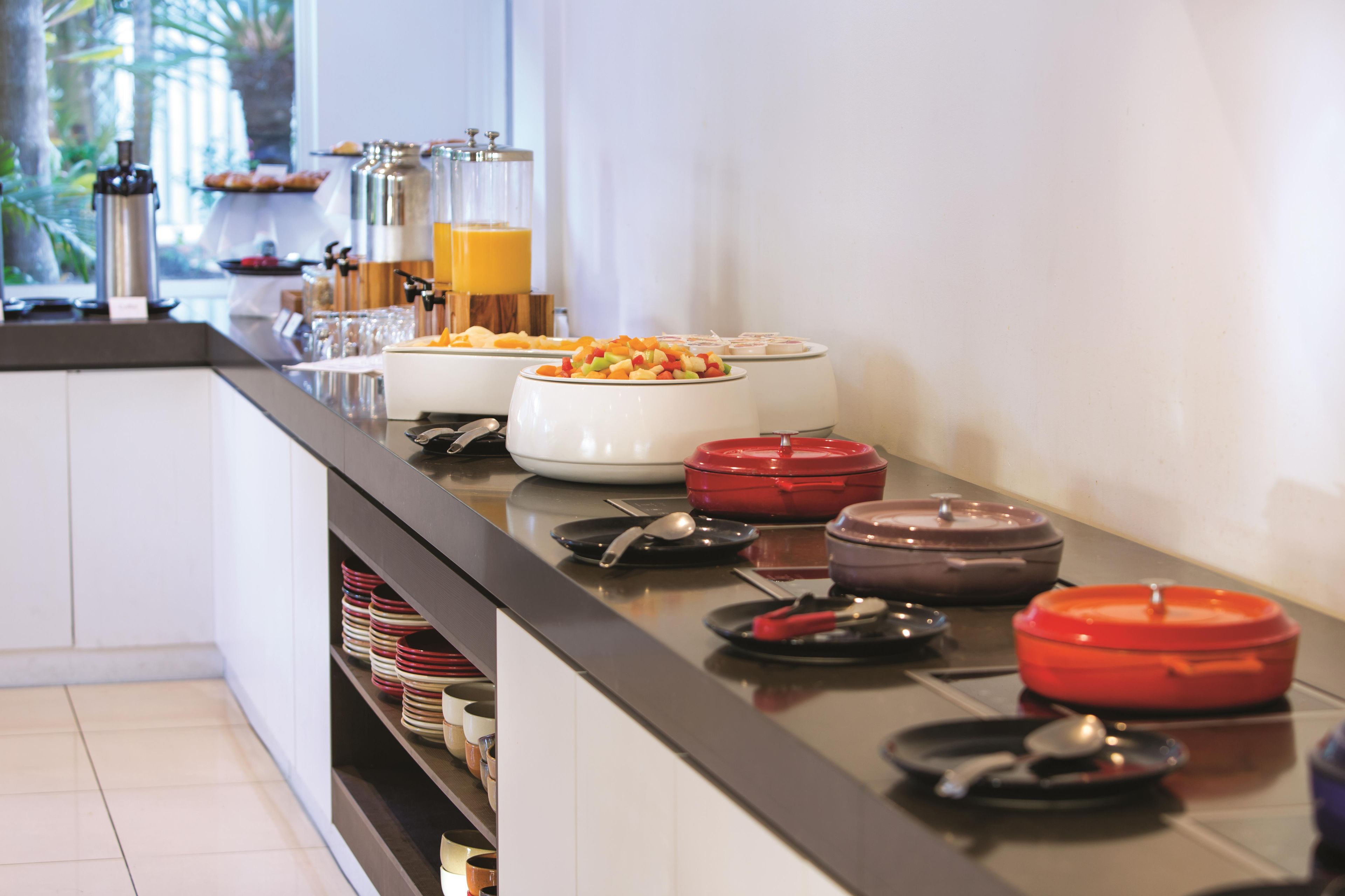 A buffet setup with various food containers and utensils.