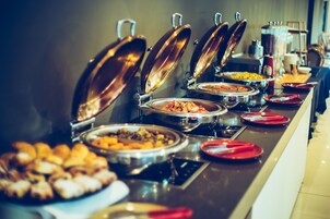Un bufé con diferentes opciones de comida y una estación de café.