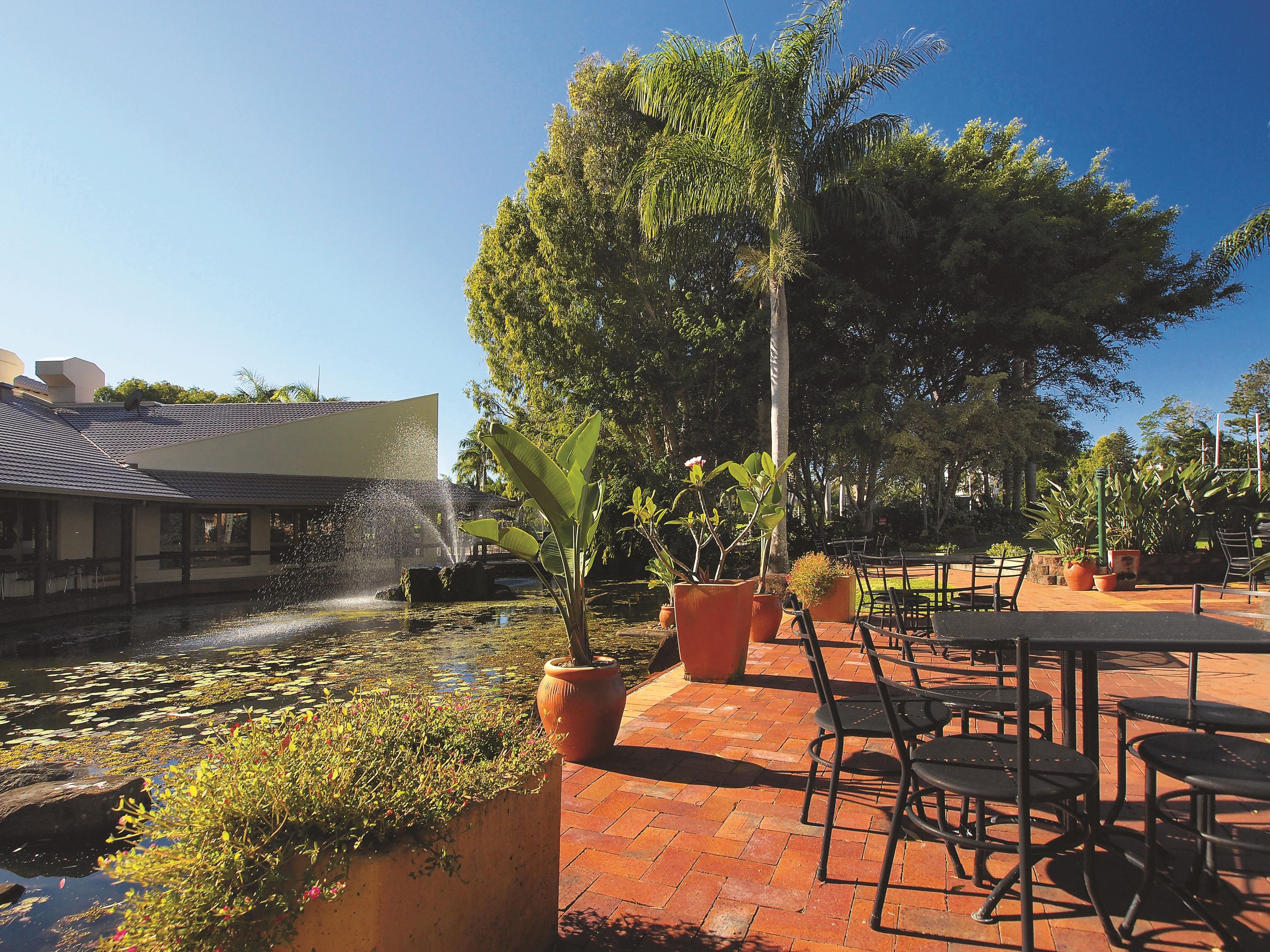 A patio area with a water feature, potted plants, and outdoor seating.
