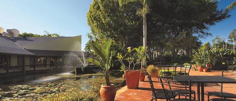A patio area with a water feature, potted plants, and outdoor seating.