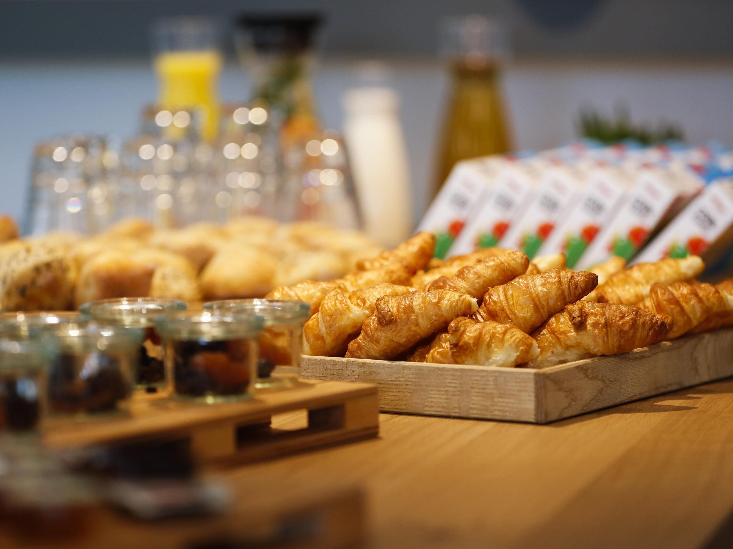 A breakfast buffet with pastries and beverages.