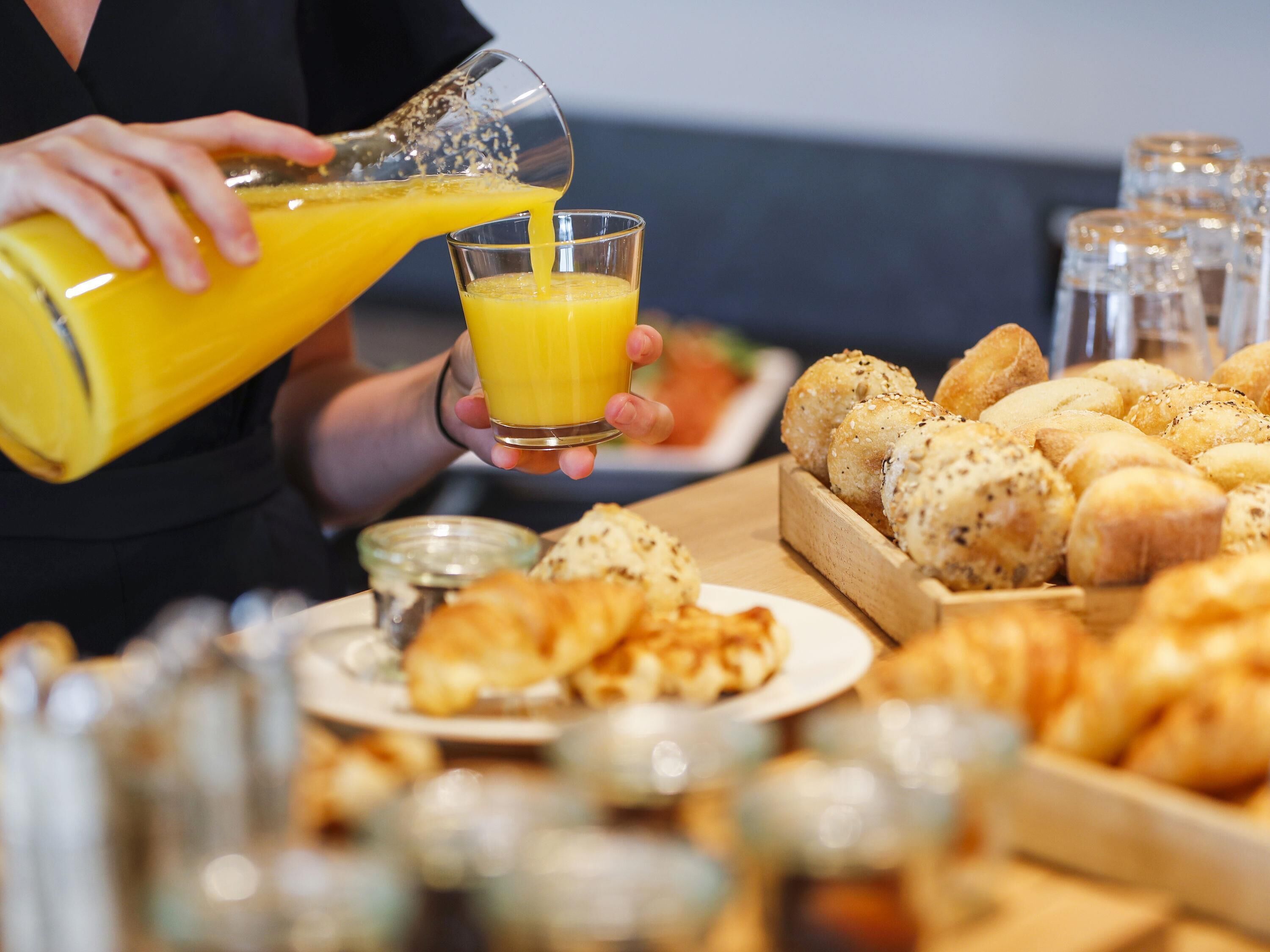 A breakfast buffet with various breads and pastries.