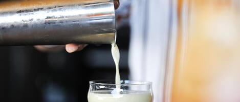 Une personne verse une boisson d’un shaker dans un verre.