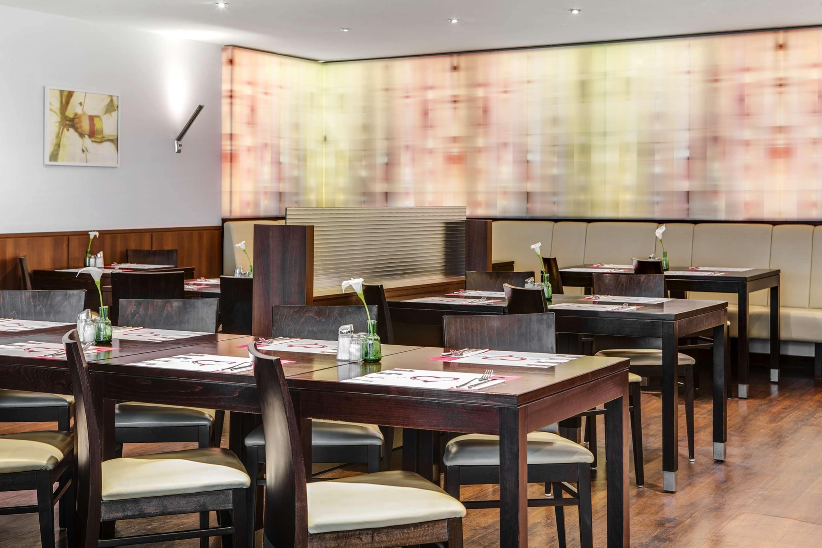 Een vergaderruimte met meerdere tafels en stoelen, voorzien van naambordjes en menu's.