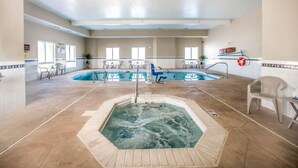 Ein großes Hallenbad mit Whirlpool, umgeben von Stühlen und einem Rettungsring.