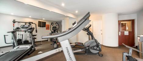 A gym with treadmills, elliptical machines, and weight equipment.