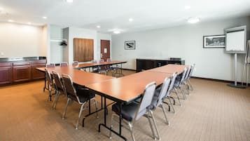 Una sala conferenze con un lungo tavolo, sedie, un proiettore e una lavagna.