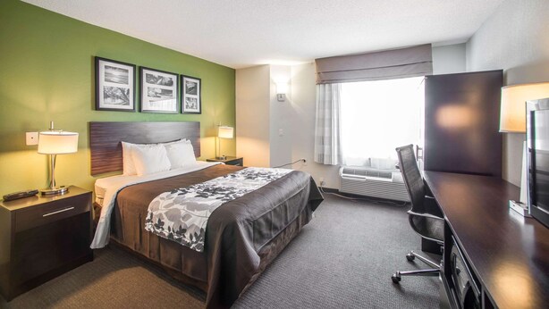 A hotel room with a bed, bedside tables, a desk, and a window with curtains. - Sleep Inn Decatur I-72 (Decatur)