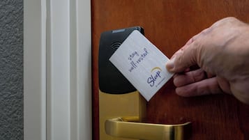 Een hand steekt een kaart in een sleutelgat.