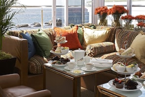 A cozy seating area with a table set for tea and snacks, overlooking a scenic view.