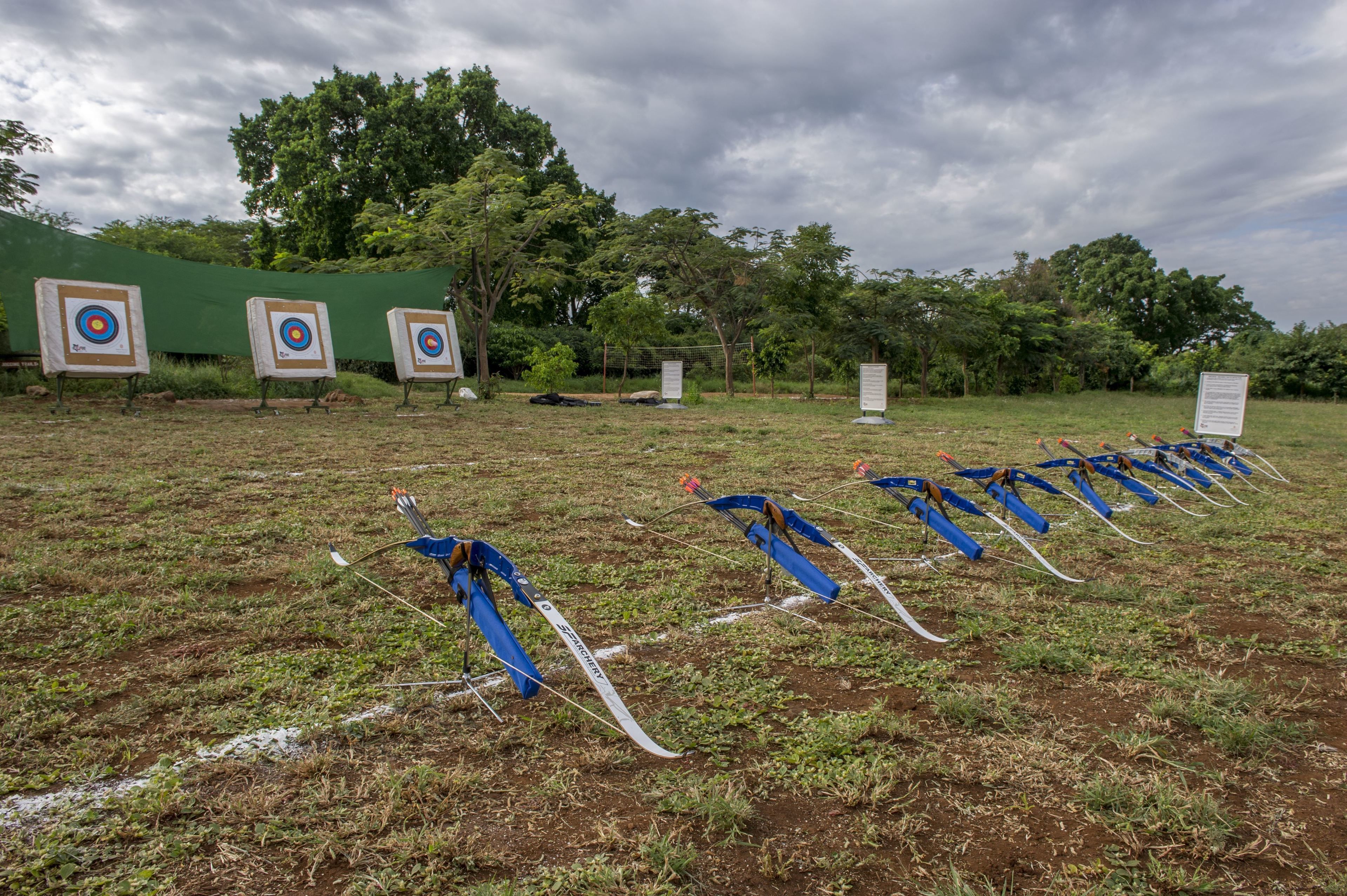 Un campo de tiro con arco al aire libre, con varios blancos y flechas dispuestas.