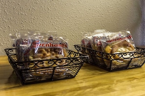 Two black wire baskets containing packaged snacks labeled 'Svenhards'. - Rodeway Inn Charlotte (Charlotte)