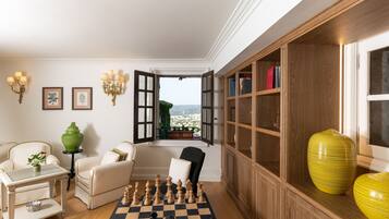 A room with a chessboard, a green vase, and a wooden bookshelf.