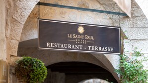 A stone archway with a sign for 'Le Saint Paul Restaurant - Terrasse'. - Le Saint Paul (Saint-Paul-de-Vence)