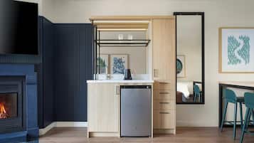A modern kitchen with a built-in dishwasher, a flat-screen TV, and a fireplace.