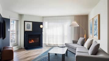 Una sala de estar con chimenea, un sofá, una mesa de centro y un tapete a rayas.