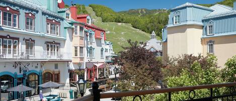 A colorful building with a balcony and outdoor seating area.