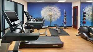 A gym with treadmills, dumbbells, and exercise equipment.