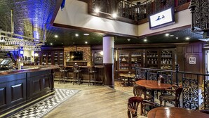 A bar area with a checkered floor, wooden furniture, and a TV screen on the wall. - Stamford Plaza Sydney Airport Hotel & Conference Centre (Sydney)