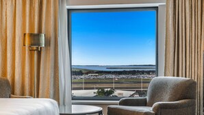 A hotel room with a large window, a bed, a chair, and a small table. - Stamford Plaza Sydney Airport Hotel & Conference Centre (Sydney)