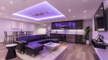 A modern living room with a sectional sofa, a coffee table, and a dining area with chairs and a table.