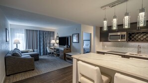 A modern hotel room with a living area, a dining area, and a kitchen. - Hampton Inn & Suites Fairfield (Fairfield)